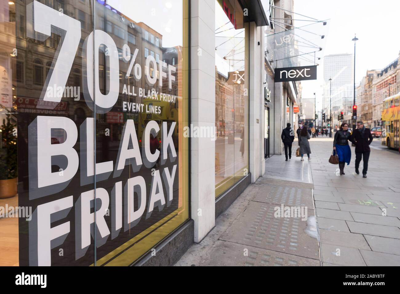 London, UK. 29th Nov, 2019. People walk past shop windows advertising 'Black Friday' sales in London, Britain on Nov. 29, 2019. Credit: Ray Tang/Xinhua/Alamy Live News Stock Photo