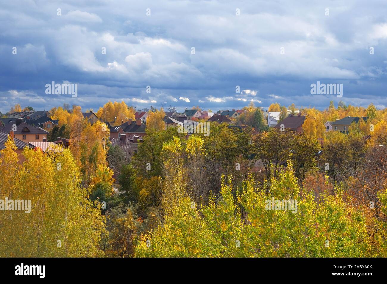 Autumn on outskirts of residence complex. Clouds in bright blue sky