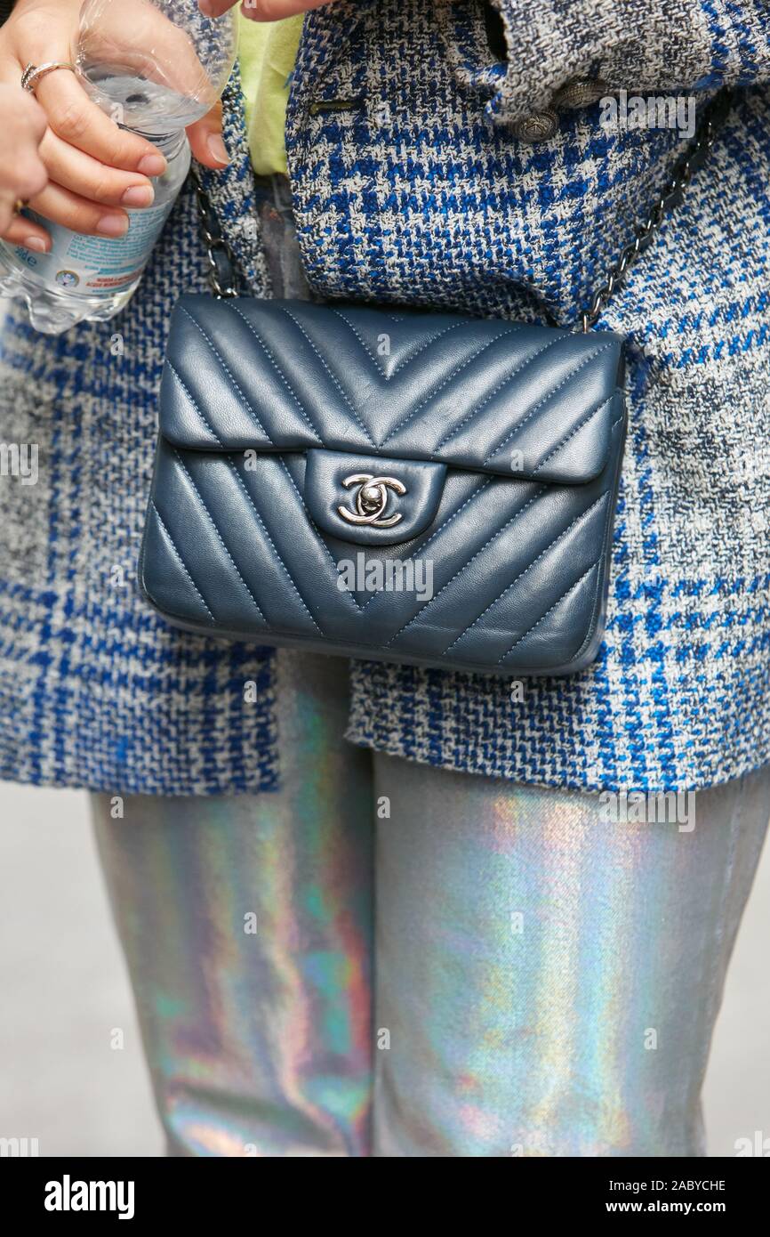 Woman with Blue Leather Chanel Bag and Iridescent Trousers before