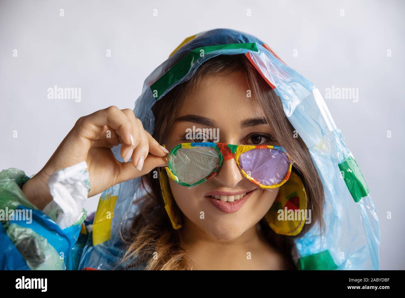Woman wearing plastic on white background. Female model in clothes and