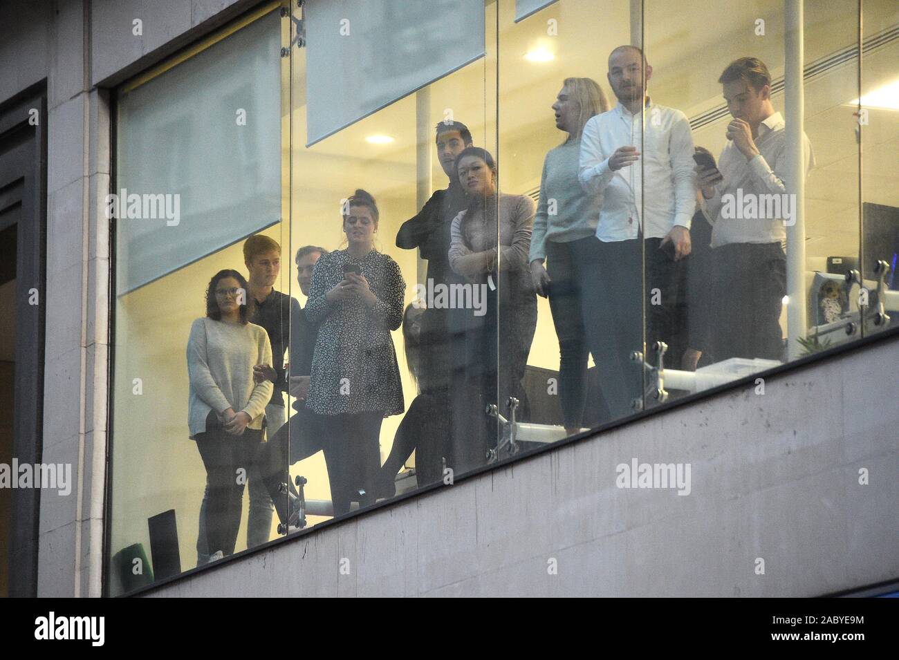 Office workers watching police near the scene of an incident on London Bridge in central London. Stock Photo