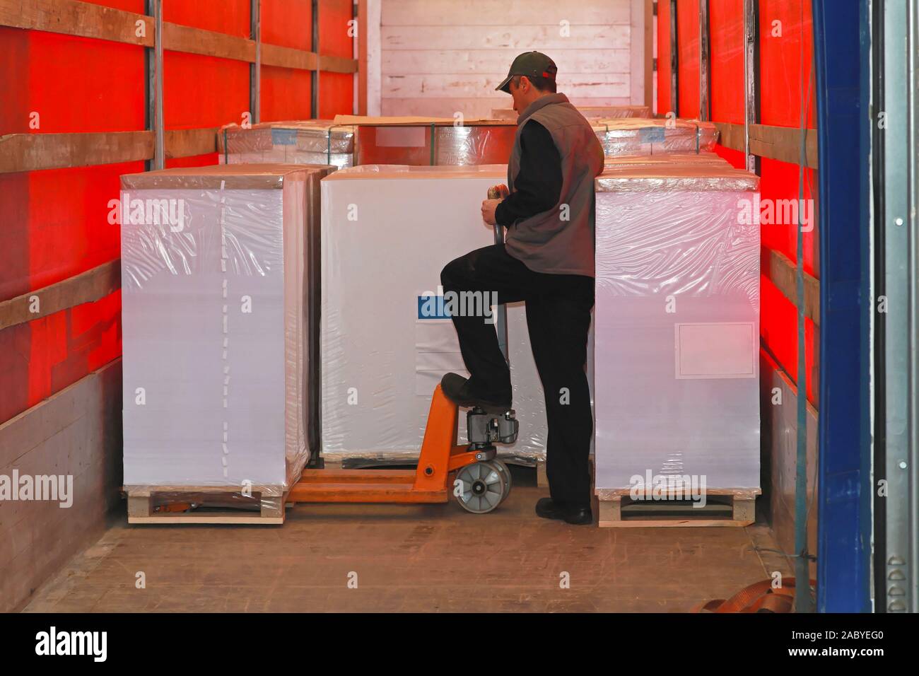 Loading goods in lorry truck with pallet jack Stock Photo - Alamy