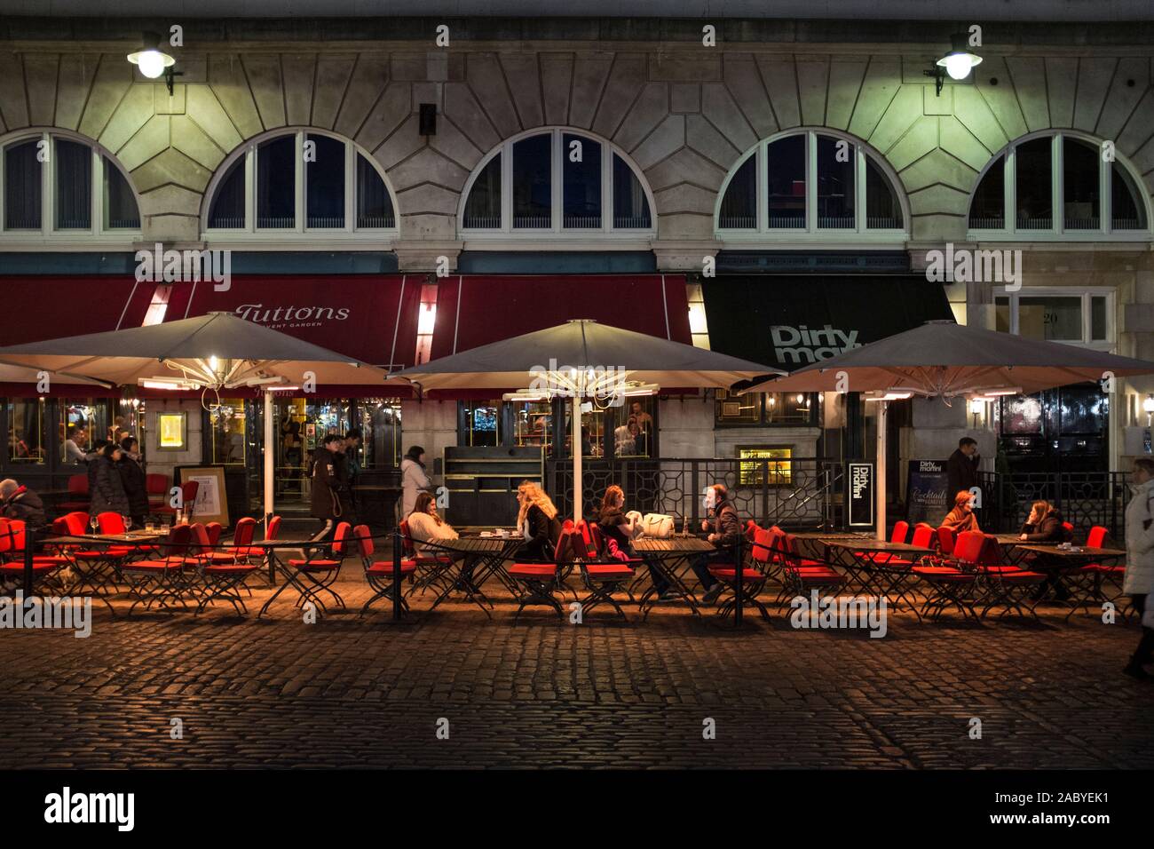 Restaurant diners near Covent Garden, sit outside under umbrellas and patio heaters at night Stock Photo