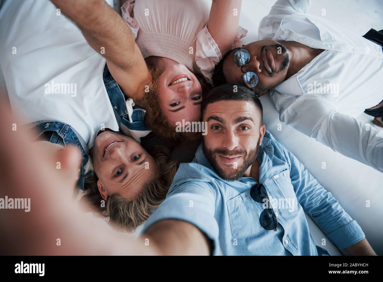 Young people laying down and take a selfie Stock Photo - Alamy