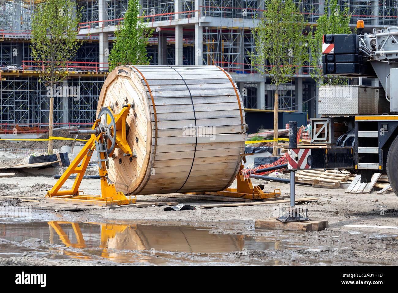 Construction site with big cable drum. Wooden coil of cable