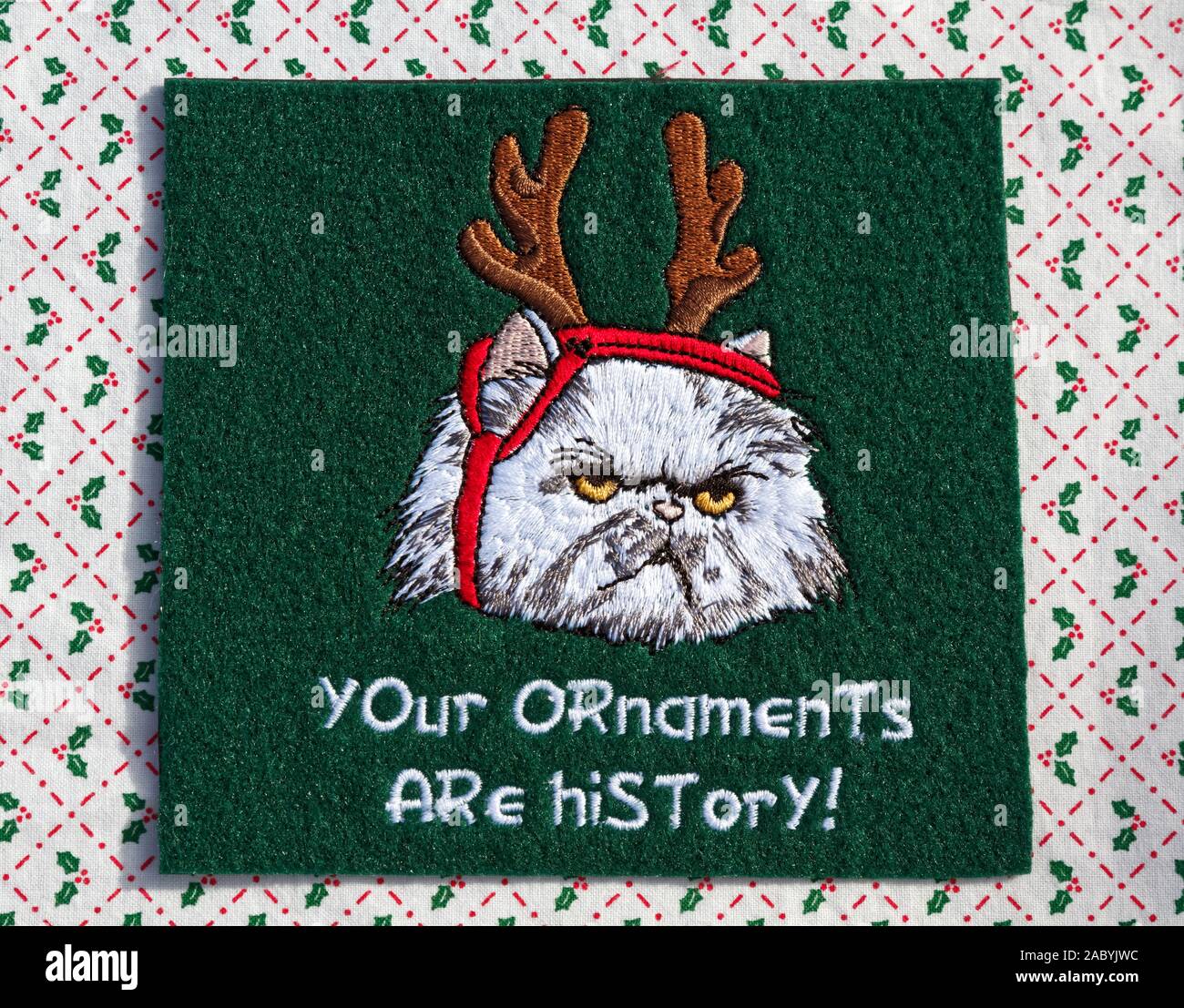 Christmas decoration, mad cat, reindeer antlers strapped on, words 'Your ornaments are history!', humorous, embroidery, holiday, horizontal Stock Photo
