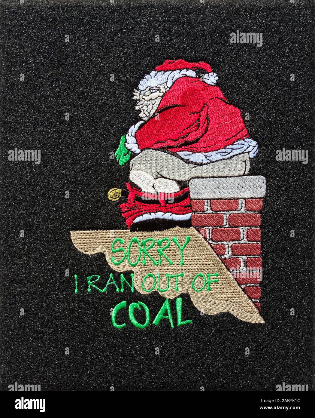 Christmas decoration, Santa, sitting on chimney, roof, pants down, using chimney as toilet, words 'Sorry I ran out of coal', humorous, black backgroun Stock Photo