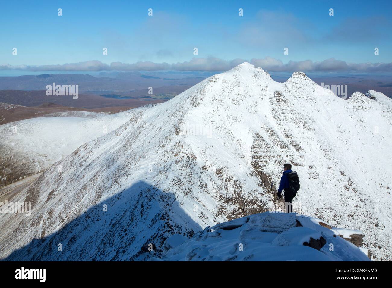 Mountaineer on the Munro An Teallach, one of Scotlands finest mountain traverses, above Dundonell, Scotland, UK, looking across to Bidein a Ghlas Thui Stock Photo