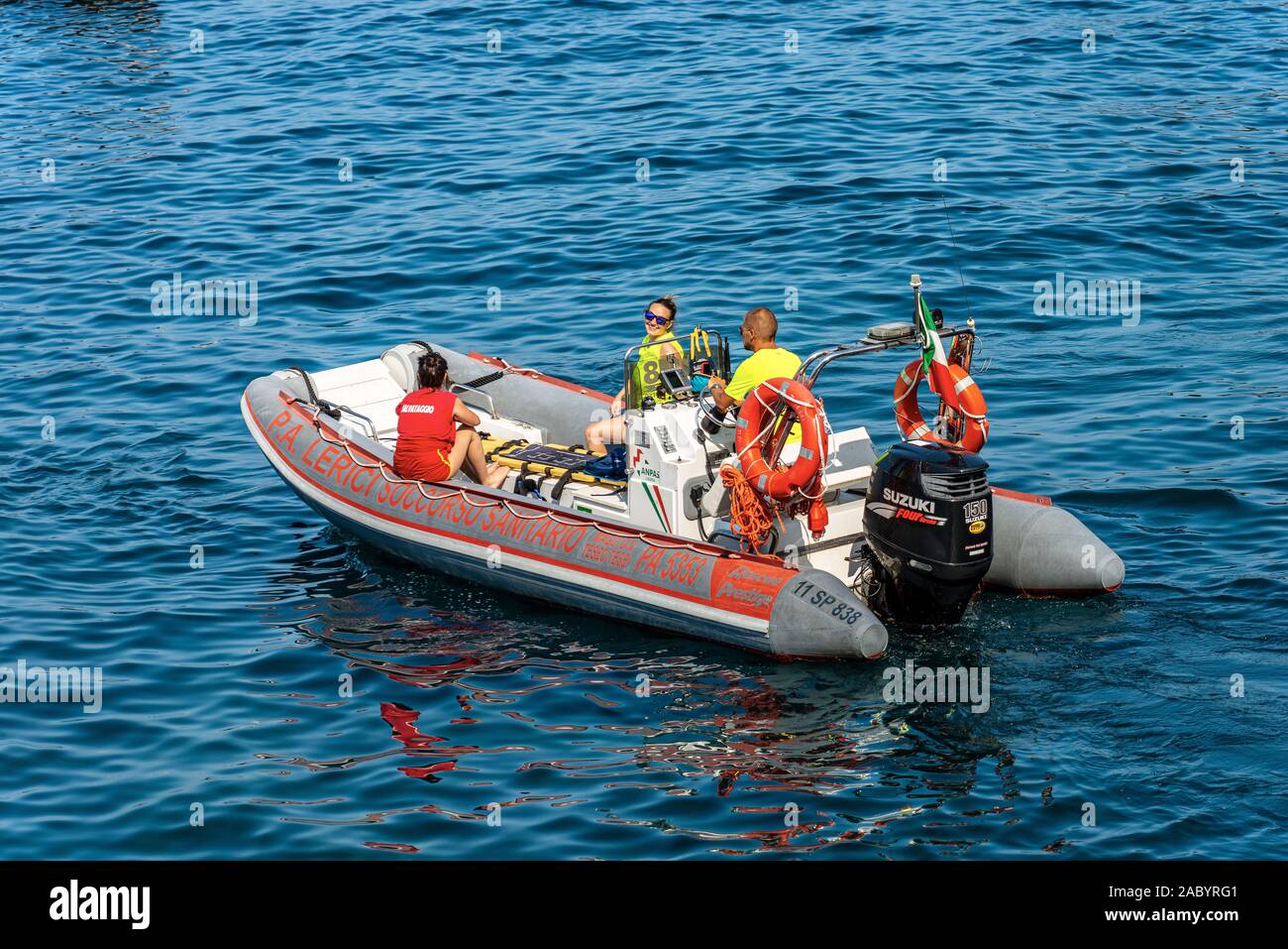 Water ambulance, small motor boat for emergency first aid with three people on board in the Mediterranean Sea, Gulf of La Spezia, Liguria, Italy Stock Photo