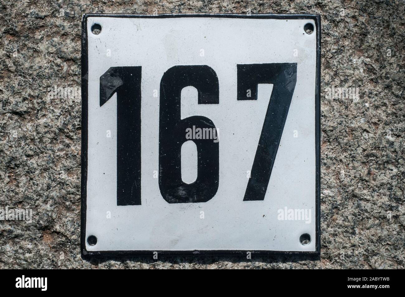 Weathered grunge square metal enameled plate of number of street address with number 167 closeup Stock Photo