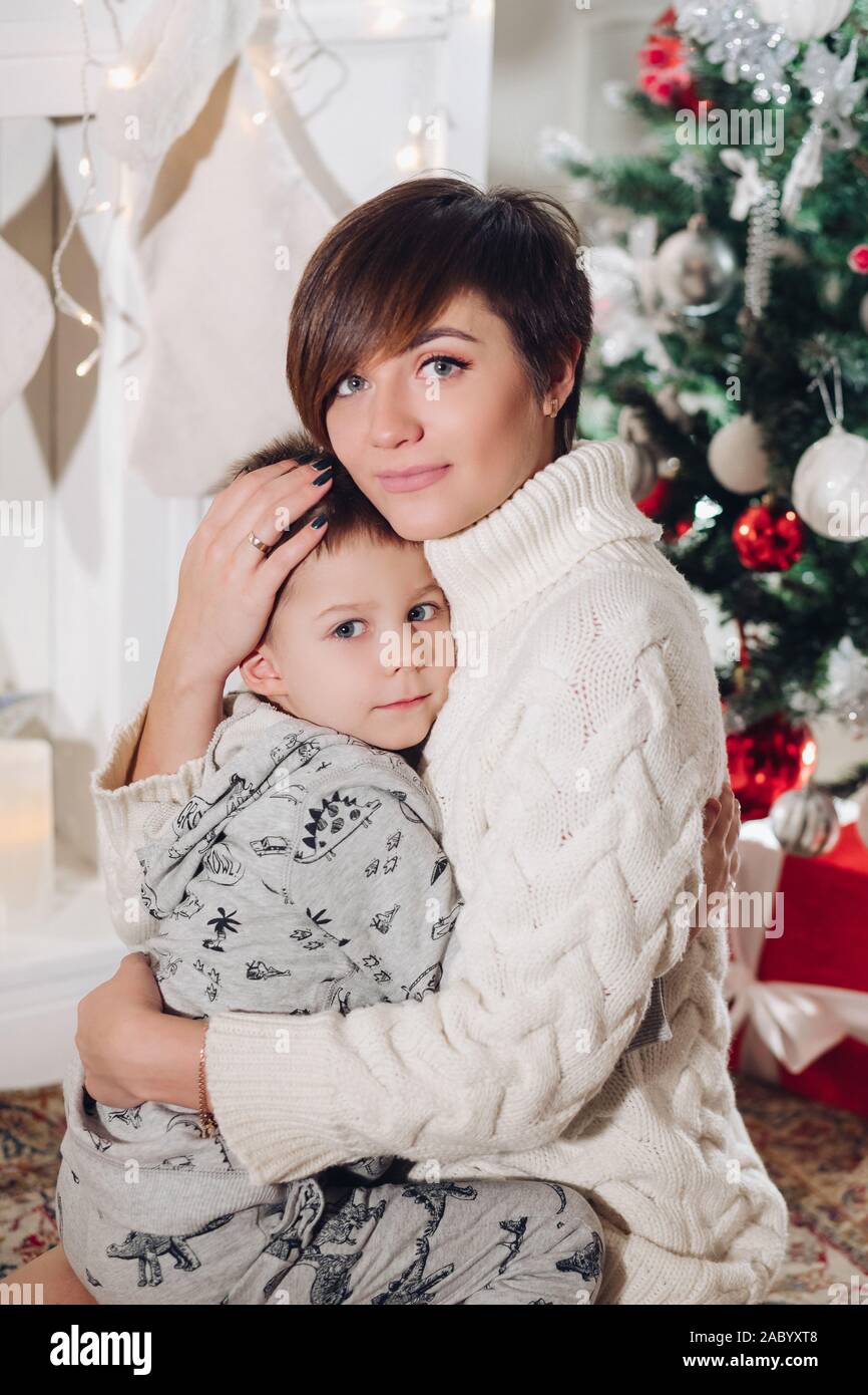 Positive Little Cute Boy With Beautiful Mom Embracing In Stylish