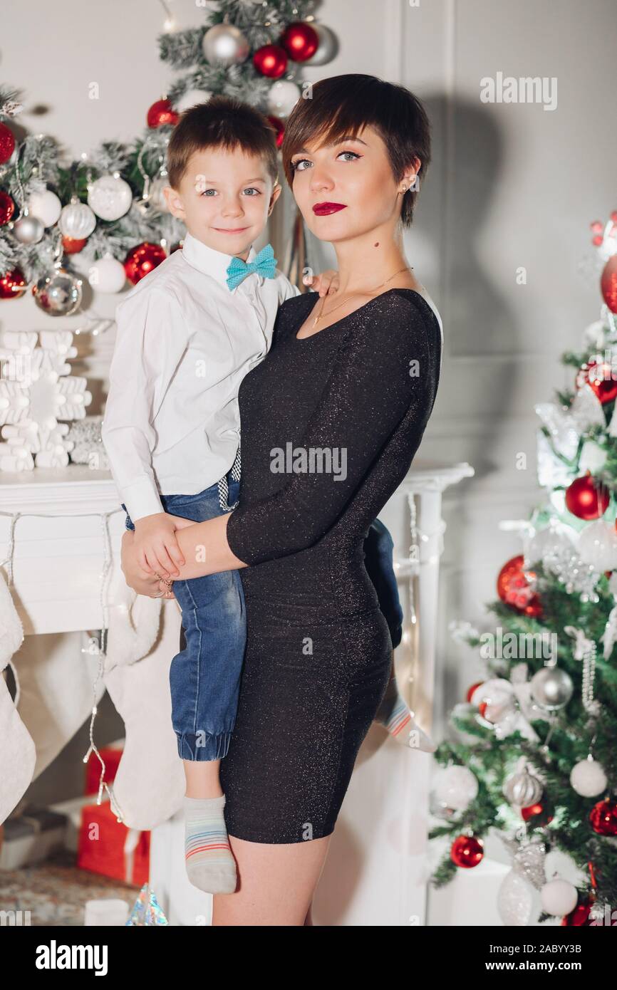 Positive Little Cute Boy With Beautiful Mom Embracing In Stylish
