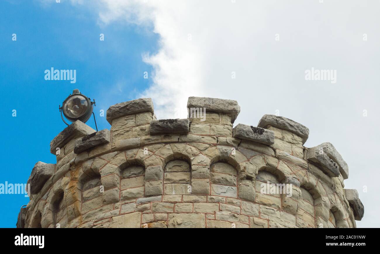 imposing vintage stone prison tower at historic  Montana State Prison under blue skies viewed from below with copy space Stock Photo