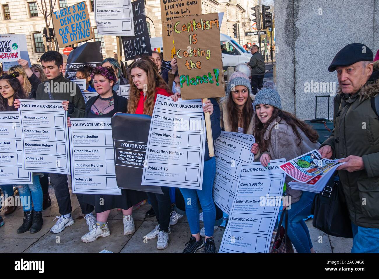 London, UK. 29th Nov, 2019. Students pose with posters listing their demands in Parliament Square before their march on Black Friday/Buy Nothing Day demanding urgent climate action. They demand a Green New Deal to save the future, a curriculum that teaches the future, for government to tell people the truth and for young people to be empowered and their views heard. Over a thousand marched up Whitehall but were stopped by police on Regent St, and led eventually back to Parliament Square were they met the UCU led march for Planet, Pay, Pensions. Credit: Peter Marshall/Alamy Live News Stock Photo