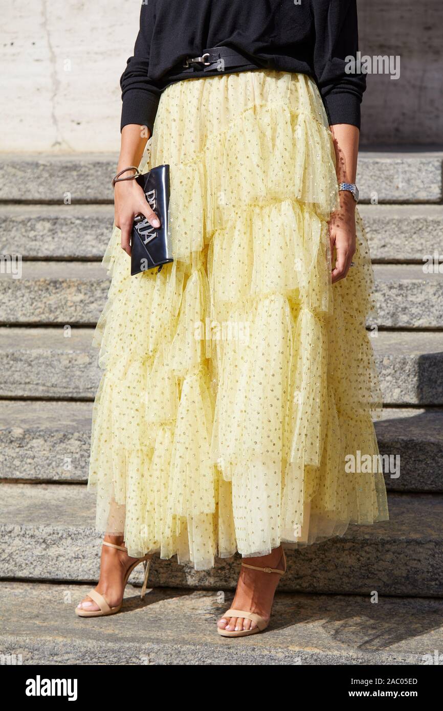 MILAN, ITALY - SEPTEMBER 19, 2019: Woman with yellow skirt and high heel shoes before Genny fashion show, Milan Fashion Week street style Stock Photo