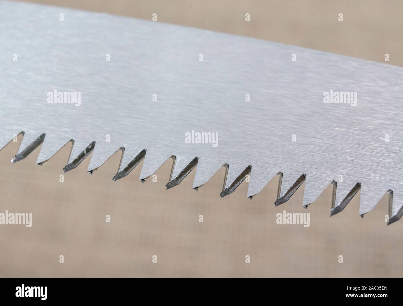 Macro close-up shot of the teeth of a short blade folding garden pruning saw. Metaphor very sharp, cutting edge, sharp teeth metal. Stock Photo