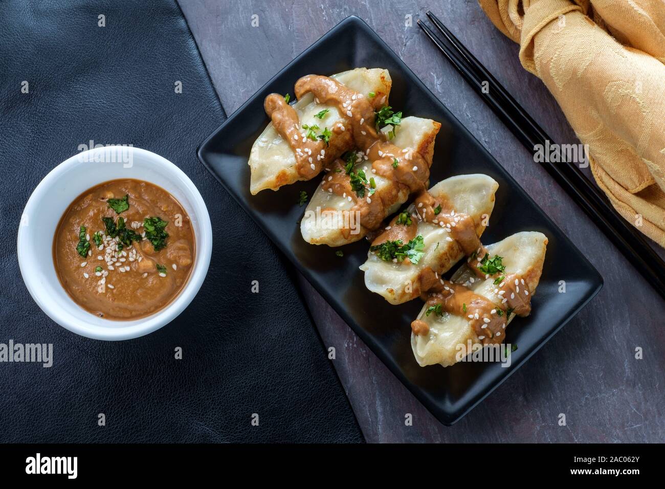 Fried Chinese Hunan pork dumplings with spicy peanut butter sauce and