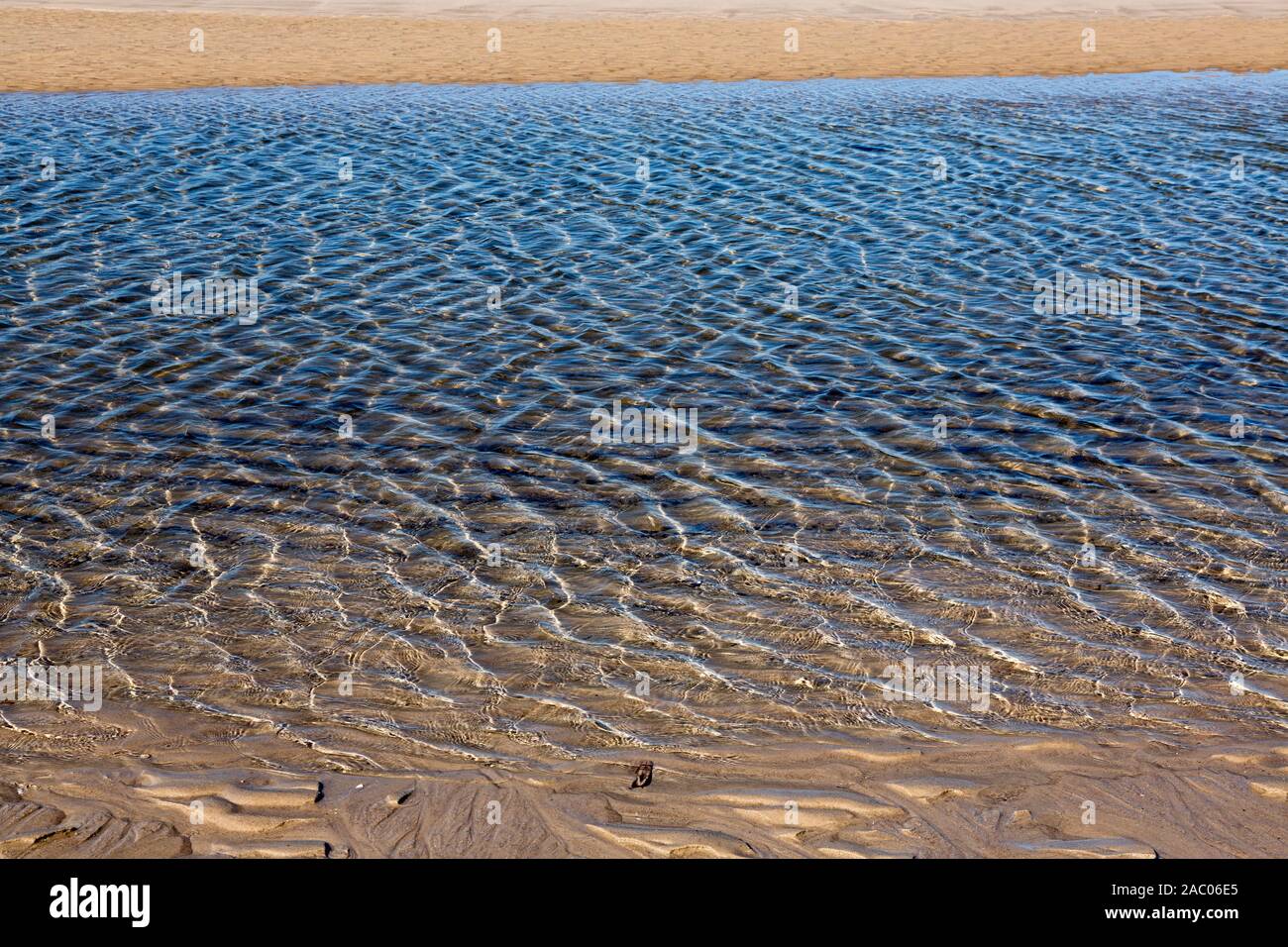 Lichtreflexe in flachem Wasser am Weststrand auf Sylt Stock Photo