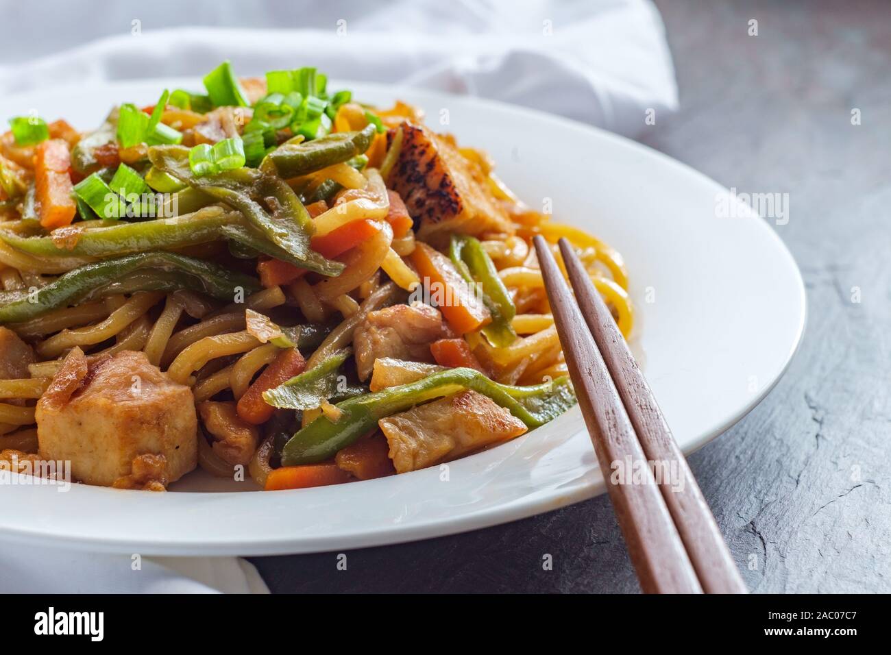 Eating Japanese chicken yakisoba noodles with chopsticks Stock Photo