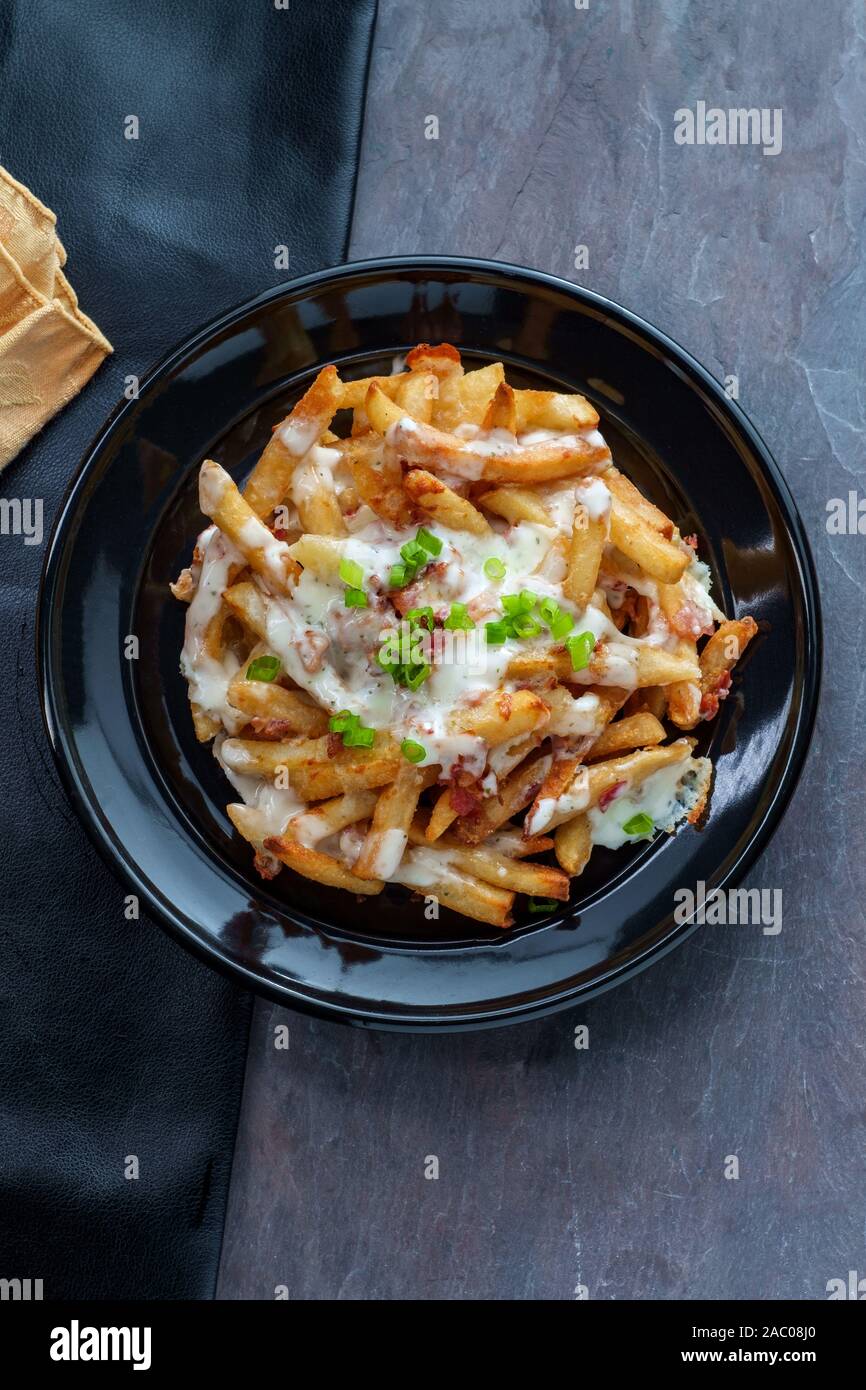 Crispy French fried potatoes loaded with bacon creamy ranch dressing and mozzarella cheese Stock Photo