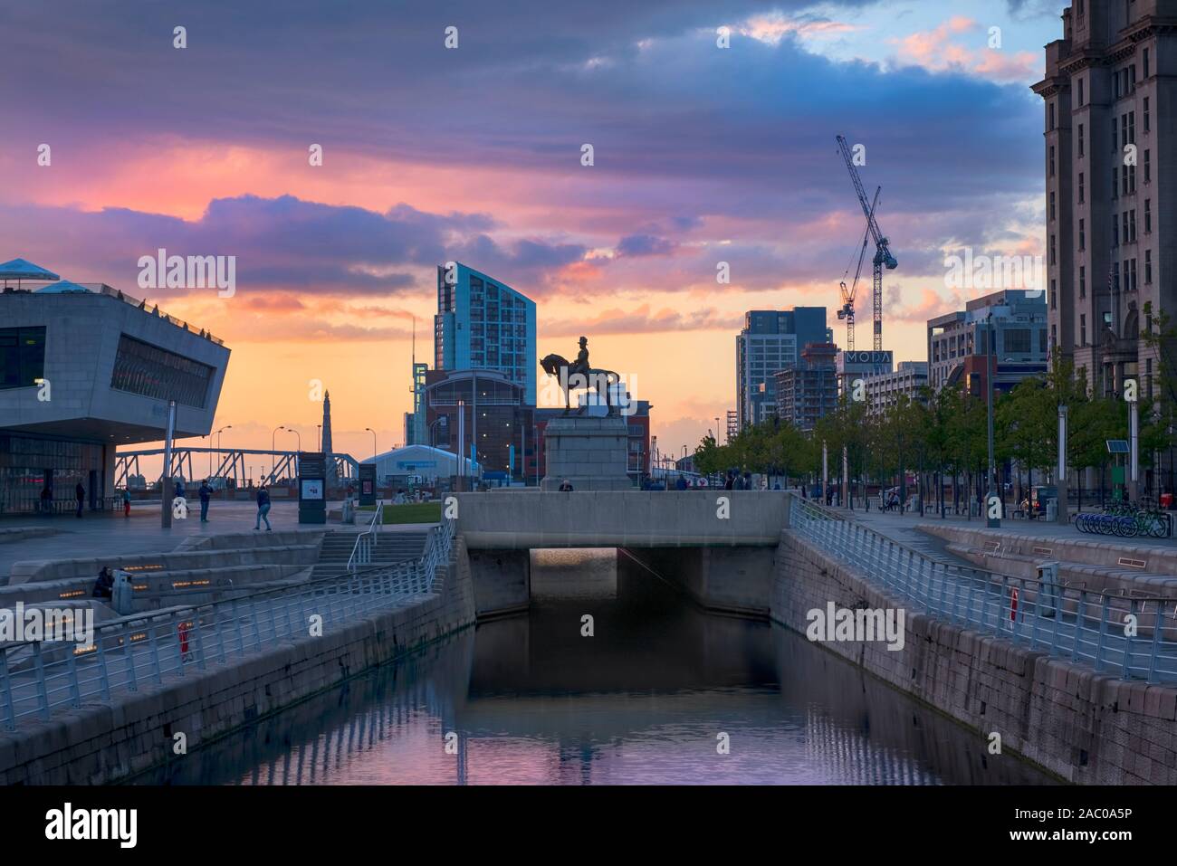 Liverpool Docks with Edward VII statue, Mersey Ferry Terminal and canal at sunset Stock Photo