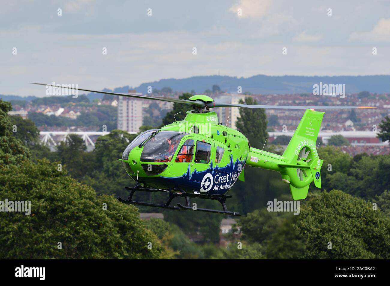 Close up of Great Western air ambulance helicopter in flight with Bristol city in the background Stock Photo