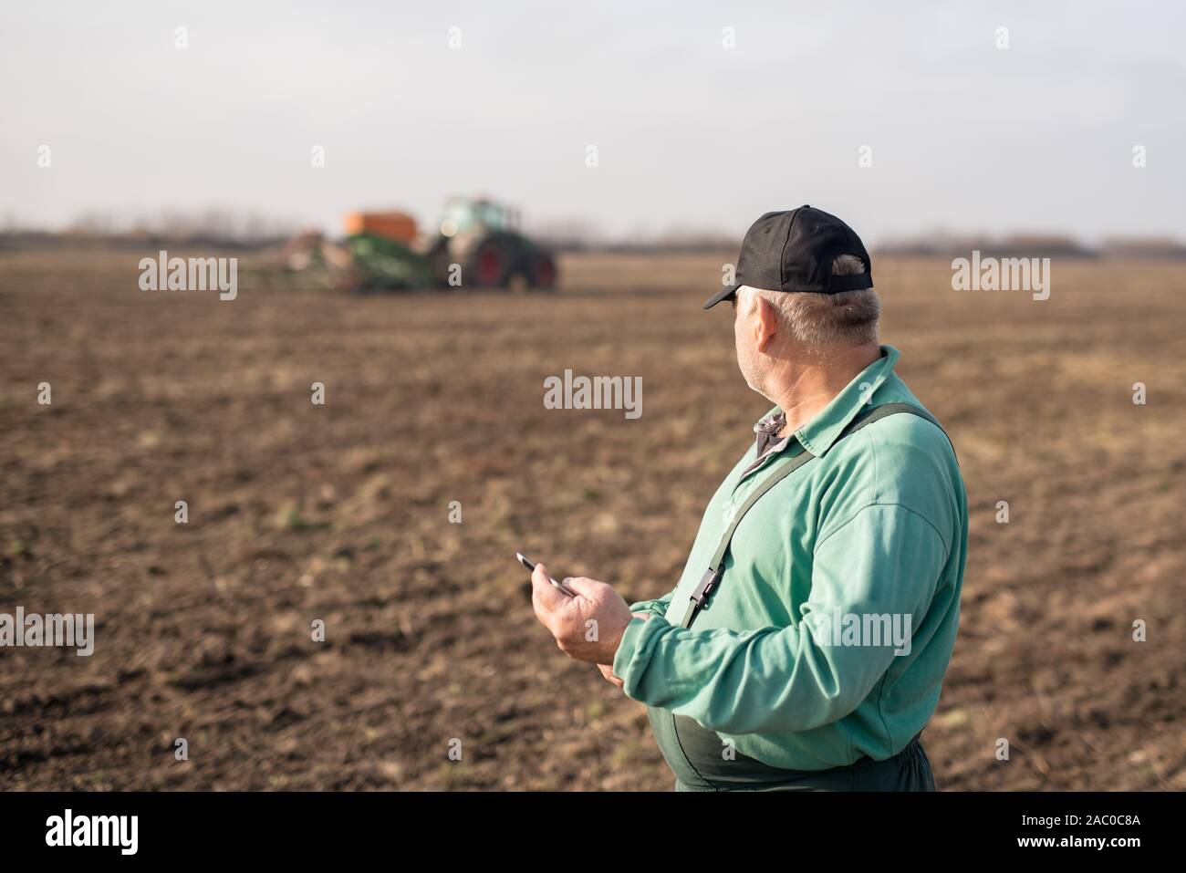 Modern senior farmer using tablet on the field Stock Photo