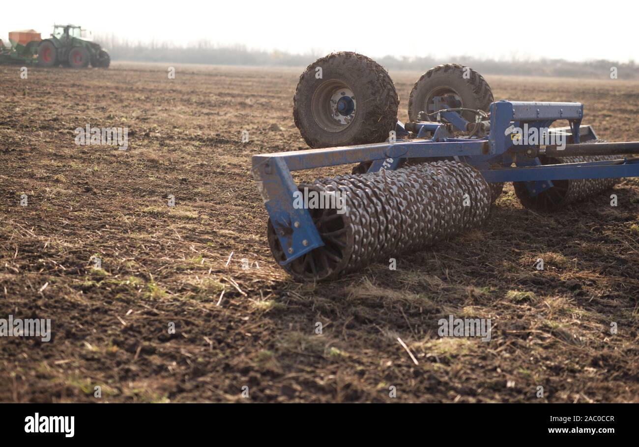 Tractor on the field cultivates the land Stock Photo - Alamy