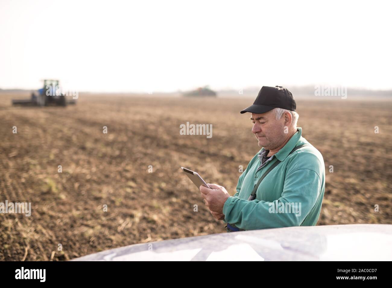 Modern senior farmer using tablet on the field Stock Photo