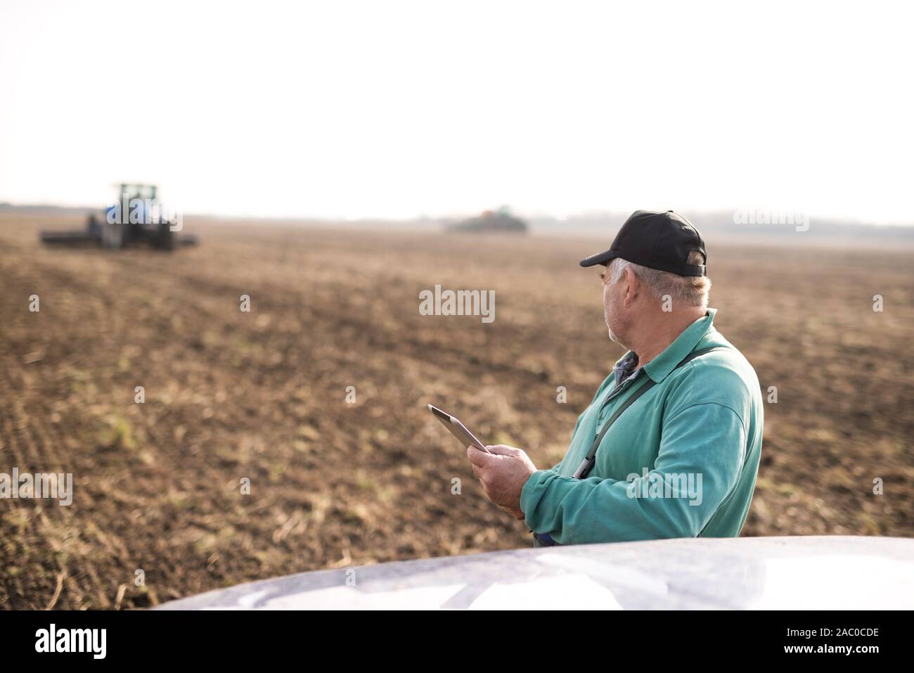 Modern senior farmer using tablet on the field Stock Photo