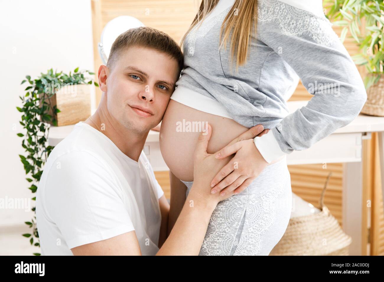 Husband kisses tummy pregnant wife hi-res stock photography and images