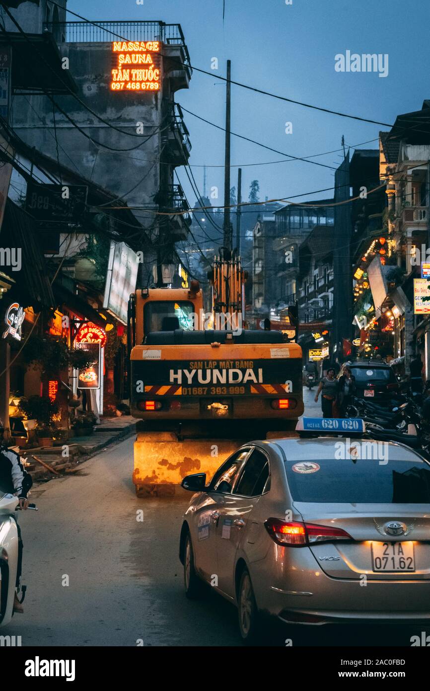 Sapa, Vietnam - 8th October 2019: Diggers travel through the narrow streets of Sapa during the night as they expand and develop the tourist town Stock Photo