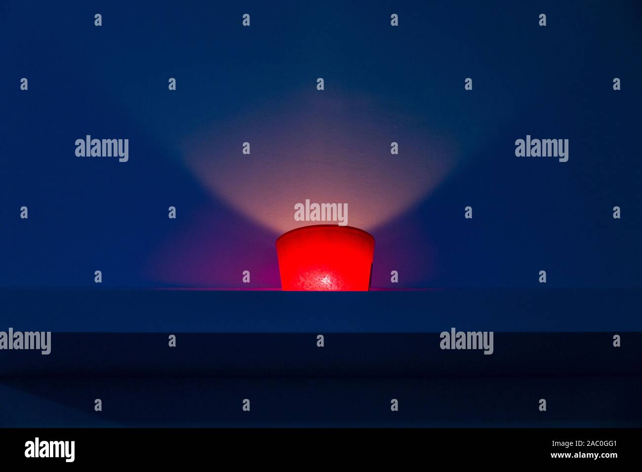 red candle on blue background inside a spa Stock Photo