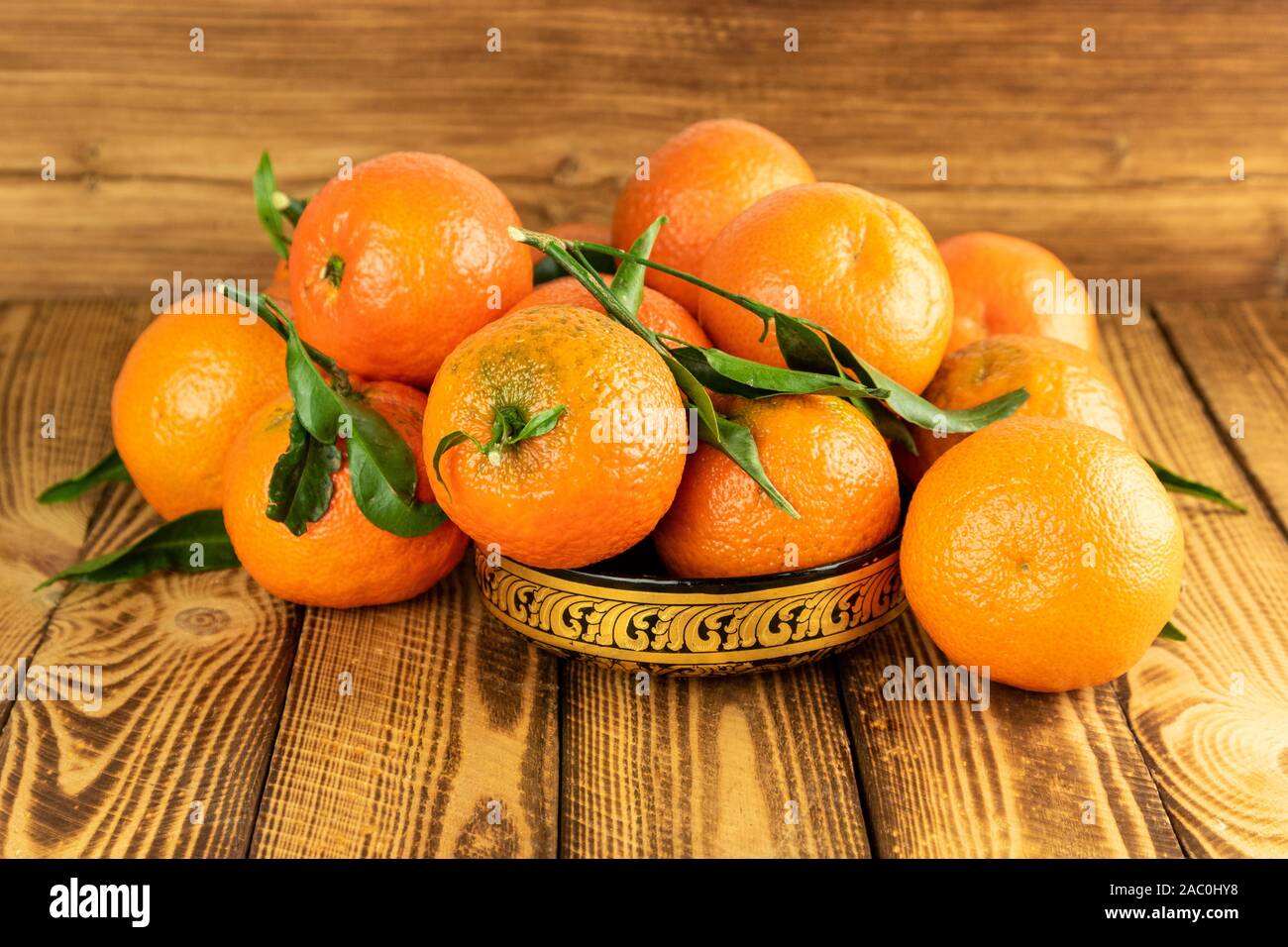 mandarin fruit in a oriental bowl on wooden table Stock Photo