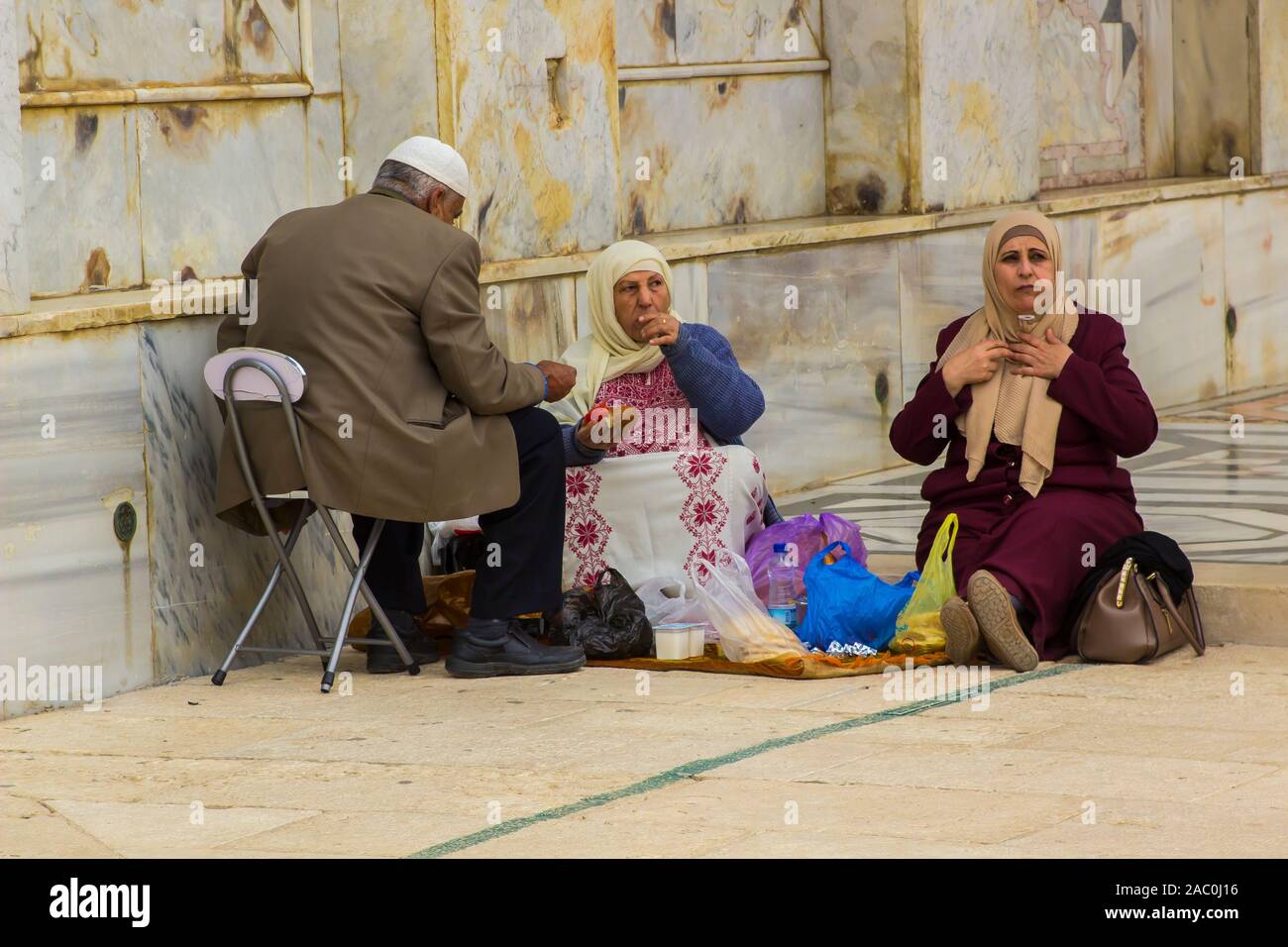 10 may 2018. An Arab man and two lady companions catch a light meal during a visit to the Dome of the Rock mosque in Jerusalem Israel Stock Photo