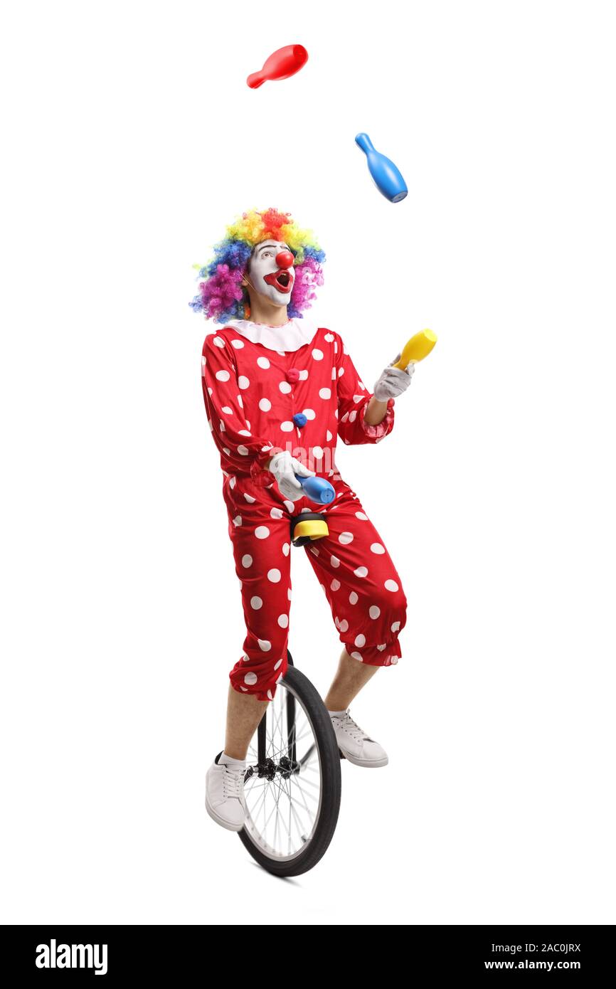 Clown on a unicycle juggling isolated on white background Stock Photo