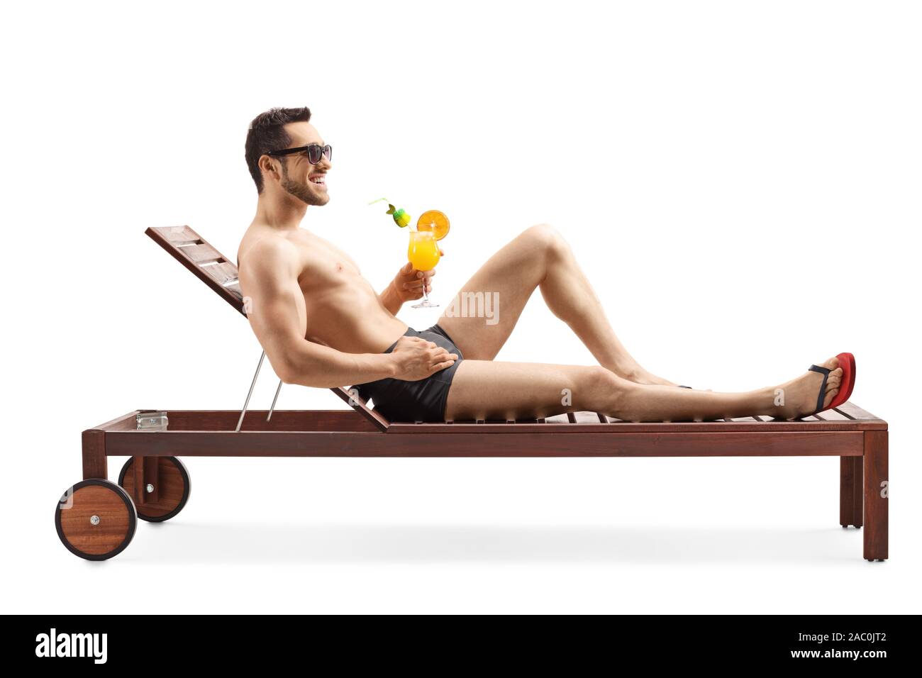 Full length shot of a handsome young man sunbathing and drinking a cocktail isolated on white background Stock Photo