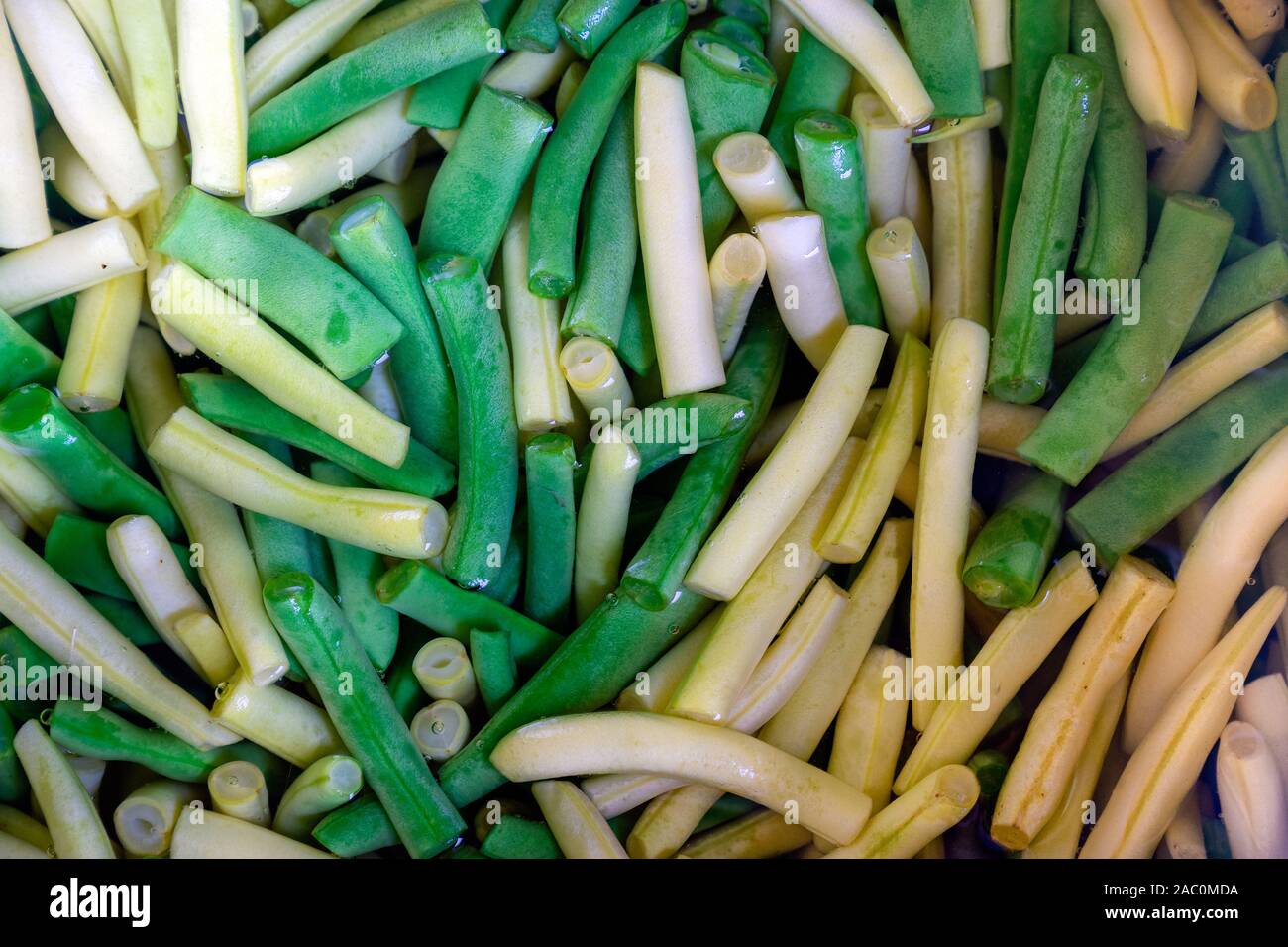 Sliced green and yellow bean are boiled in water in a saucepan. Close-up view Stock Photo