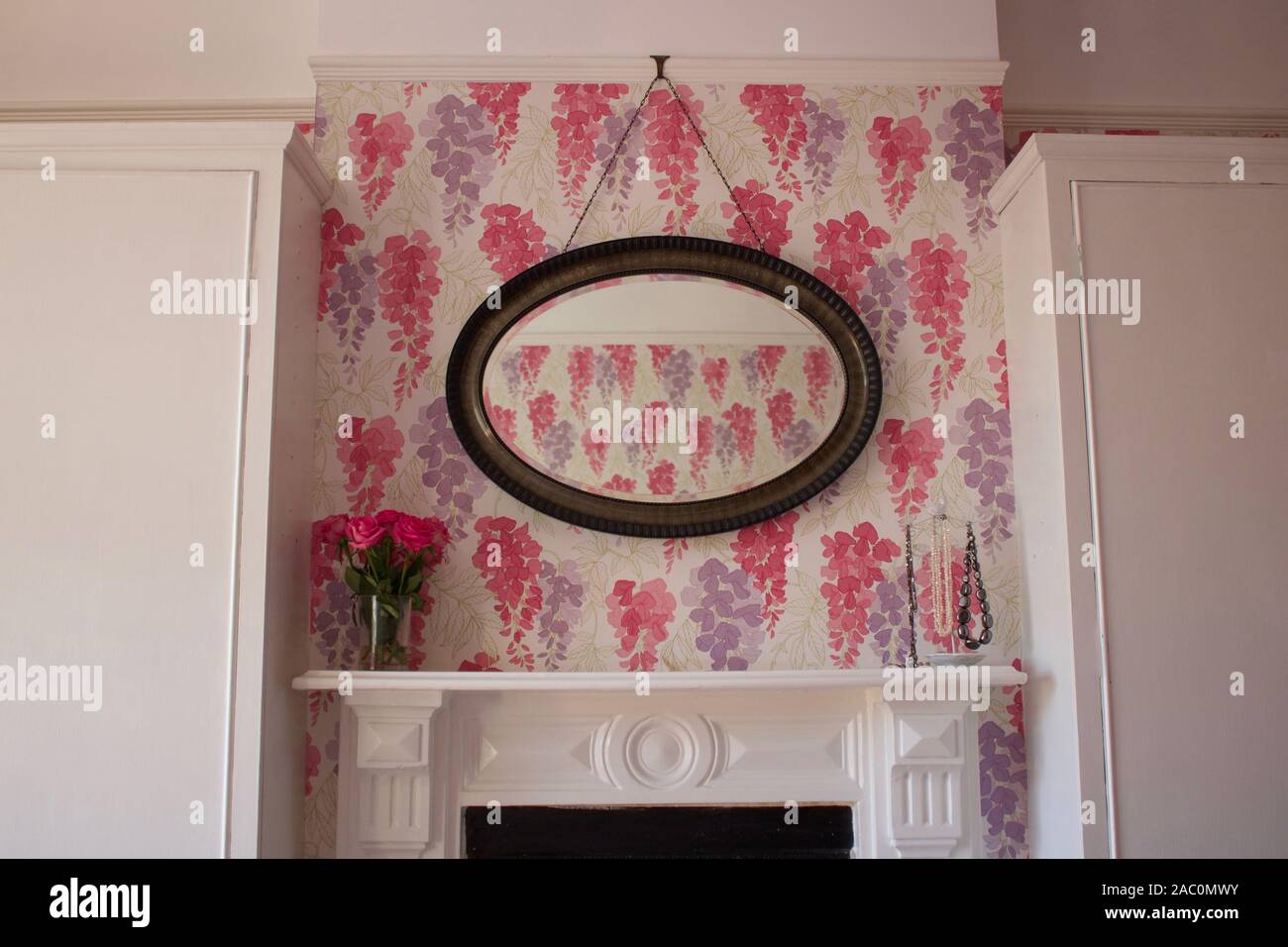 Victorian style bedroom with floral wallpaper and fireplace Stock Photo