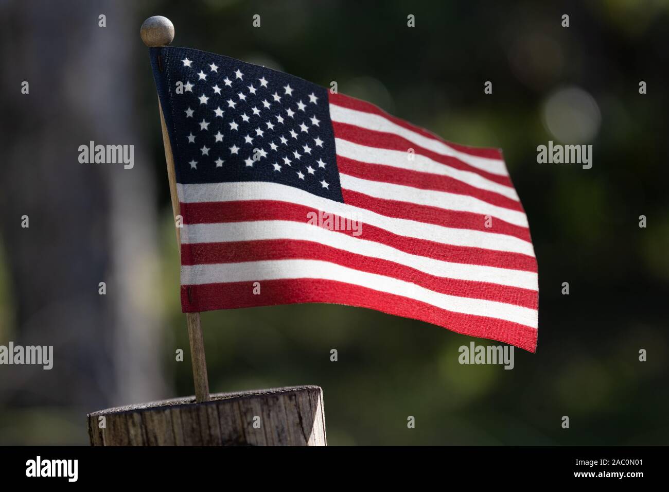Closeup of small American Flag on a wooden post Stock Photo