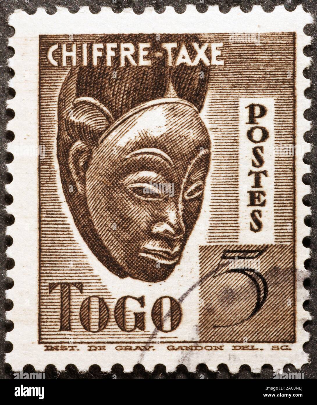 Wooden african mask on postage stamp of Togo Stock Photo