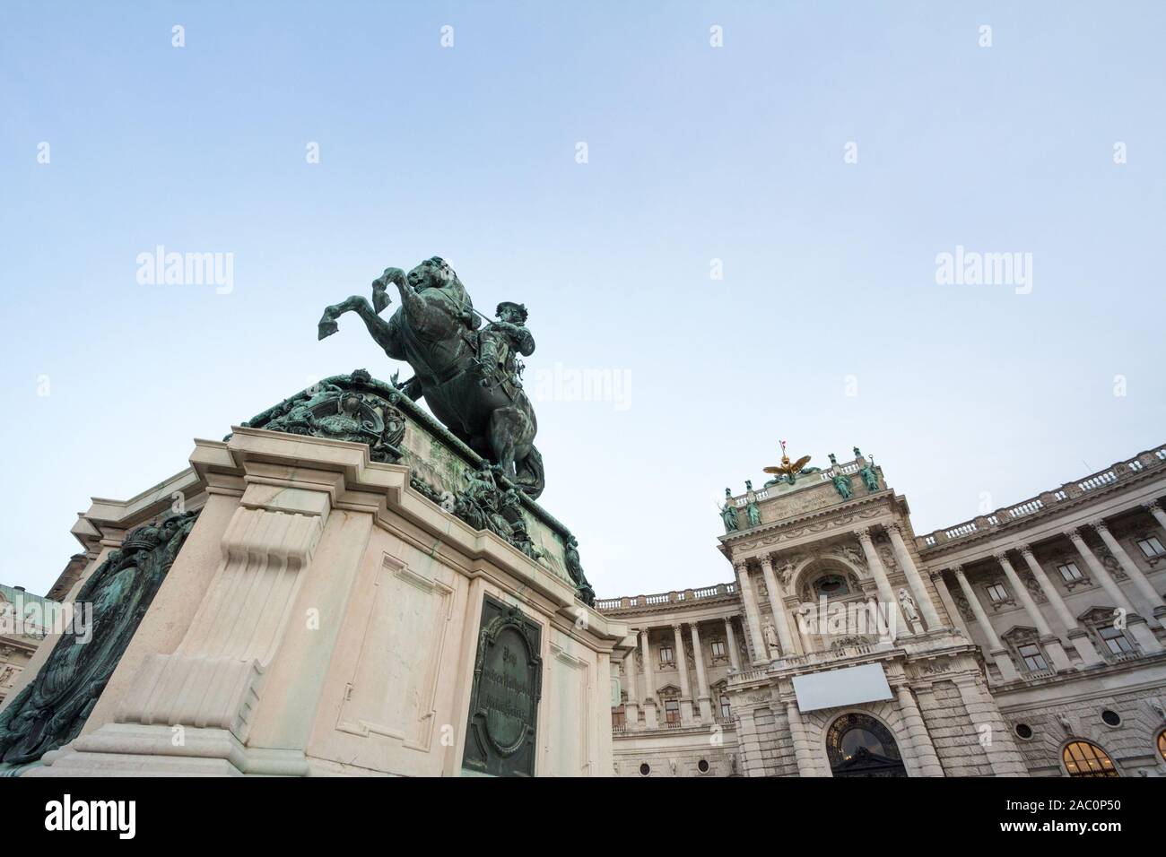 Hofburg palace, on its Neue Burg aisle, taken from the Heldenplatz square, with the 19th century Prinz Eugen statue in front in Vienna, Austria. It is Stock Photo