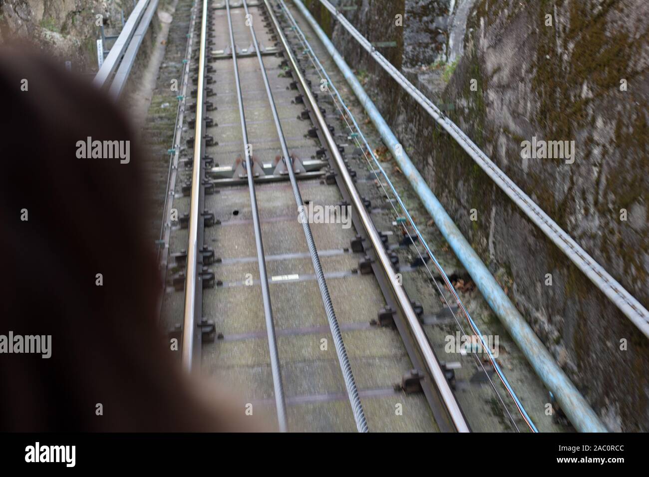 The rails with cable of the panoramic funicular that leads from Como to Brunate Stock Photo