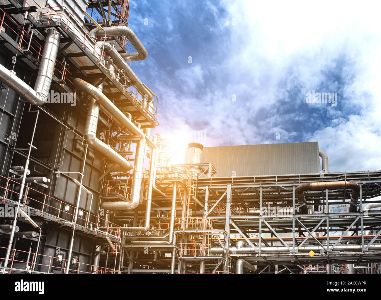 Oil and gas industrial refinery zone,Detail of equipment oil pipeline steel with valve from large oil storage tank at twilight. Stock Photo