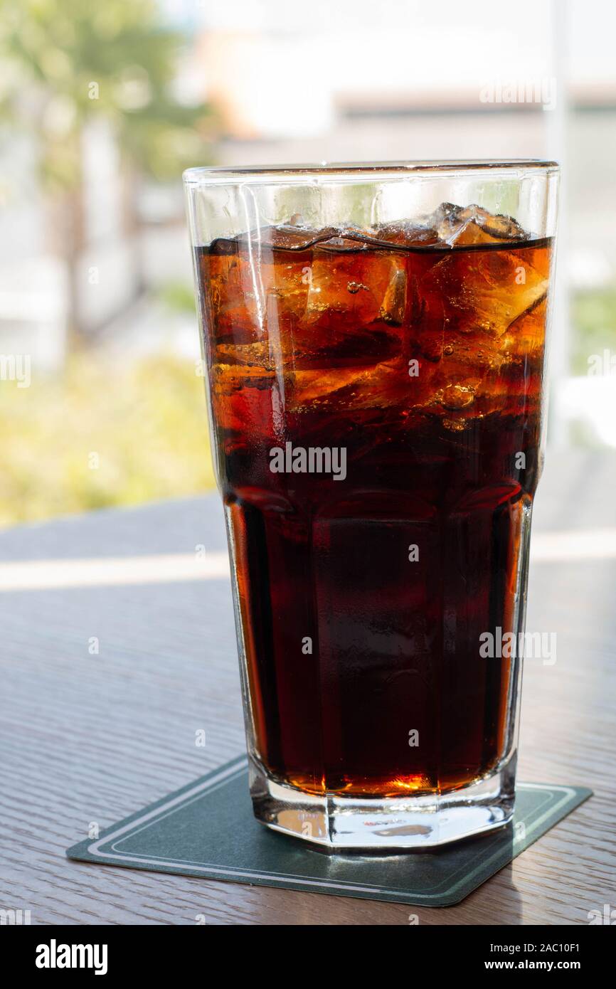 glass of cold soft drink on wooden bar with blurred summer view Stock Photo