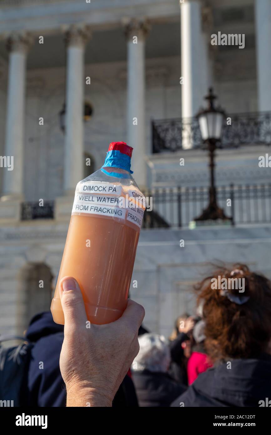 Washington, DC - 29 November 2019 - A protester holds a jar of well water from an area where fracking is taking place at a rally at the U.S. Capitol. It was one of a series of weekly 'Fire Drill Fridays' led by Jane Fonda, demanding that political leaders take action on the climate change crisis. Thirty-eight people were arrested when they refused to leave the Capitol steps. Credit: Jim West/Alamy Live News Stock Photo