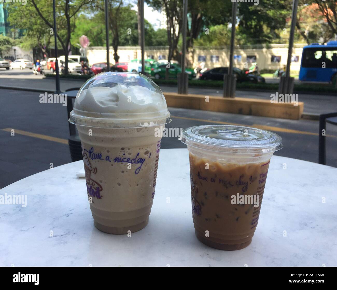 Saigon, Vietnam - Jan 6, 2019. Iced coffee (Vietnamese style) in take away cup plastic glass on the table. Plastic products pollute the environment. Stock Photo