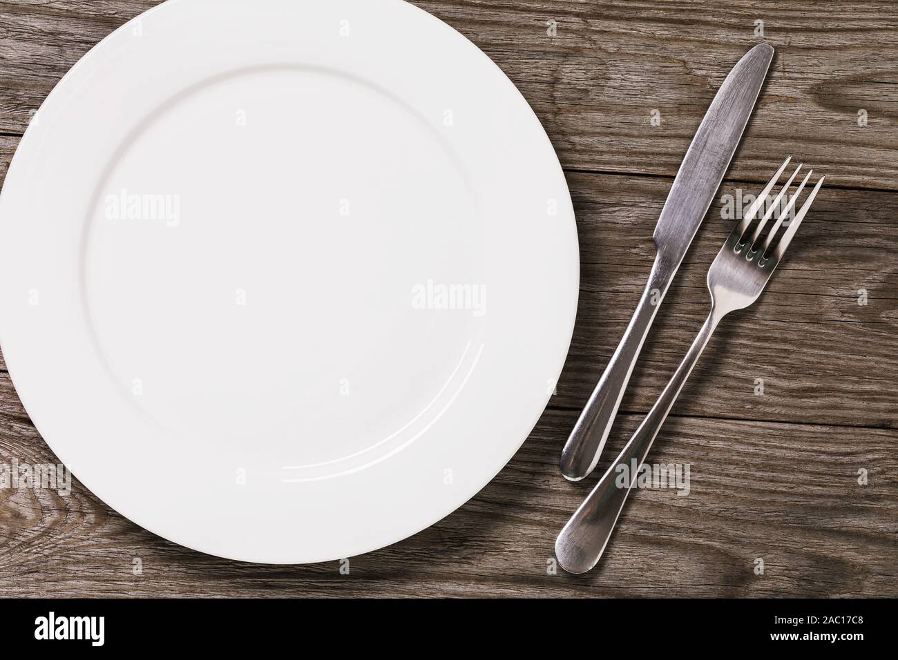 Empty plate and cutlery on a wooden table with copy space, top view ...