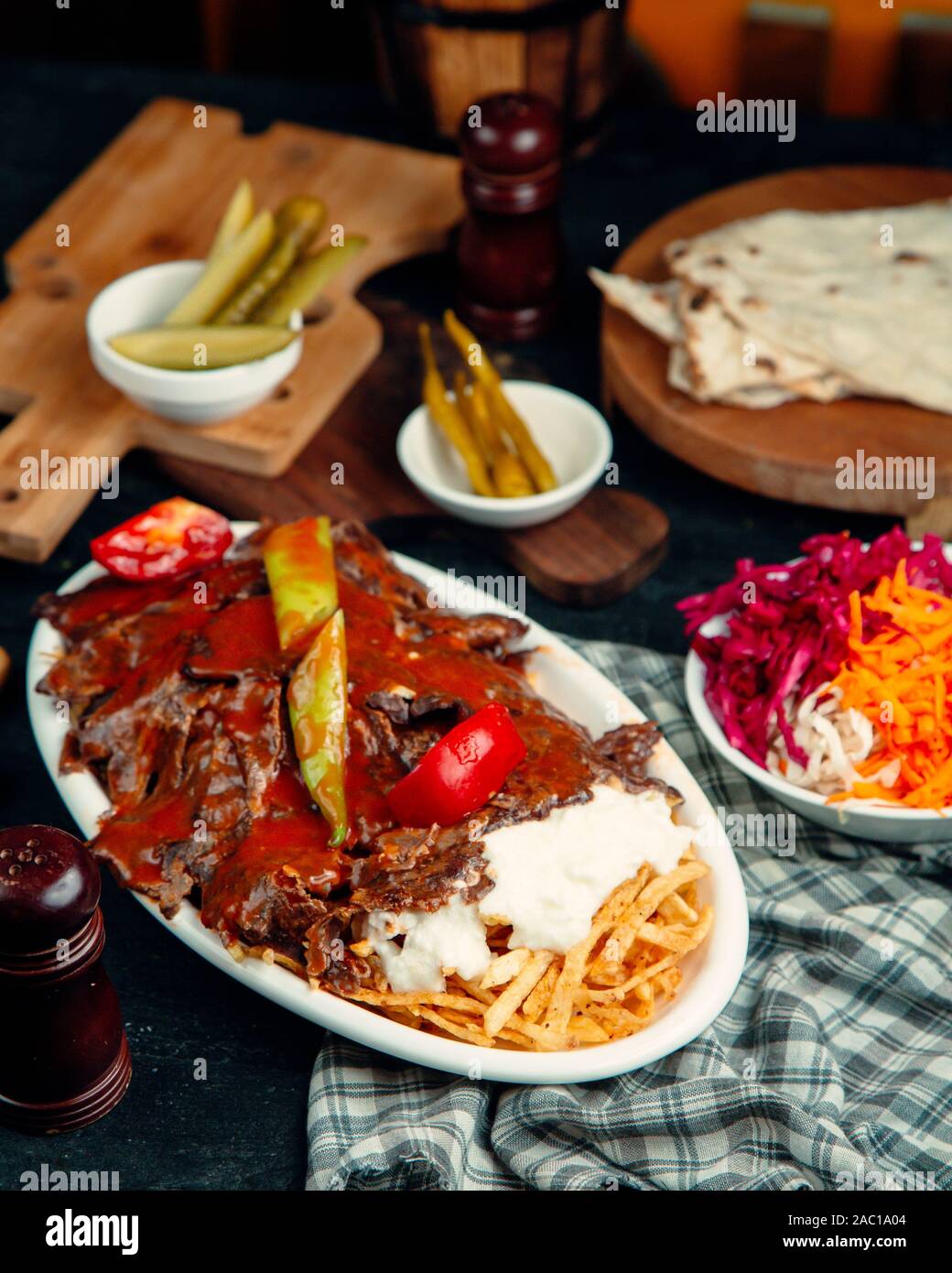 iskender kebab garnished with tomato sauce, served with potato and