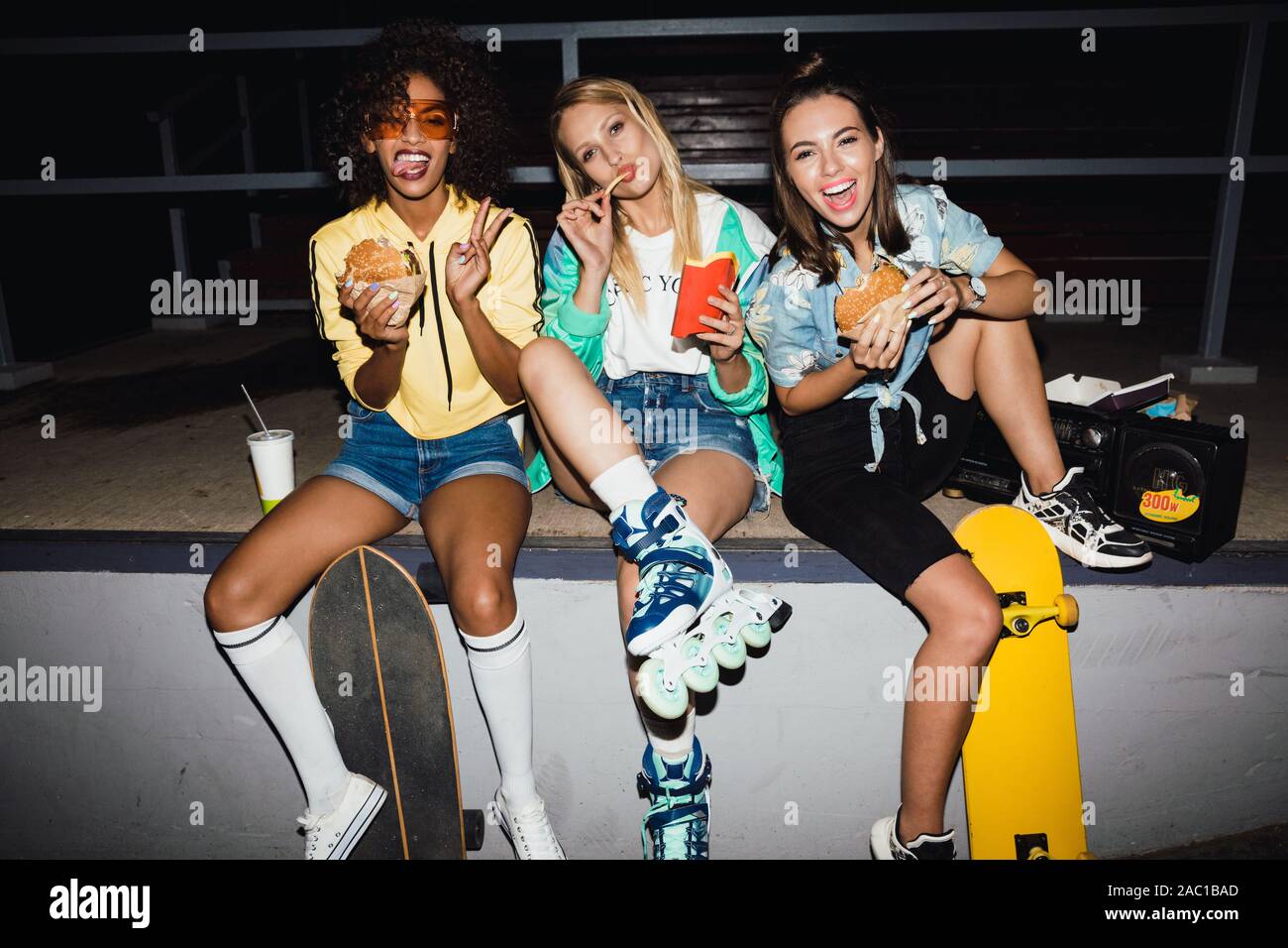 Image of a young positive optimistic girls friends at night on street